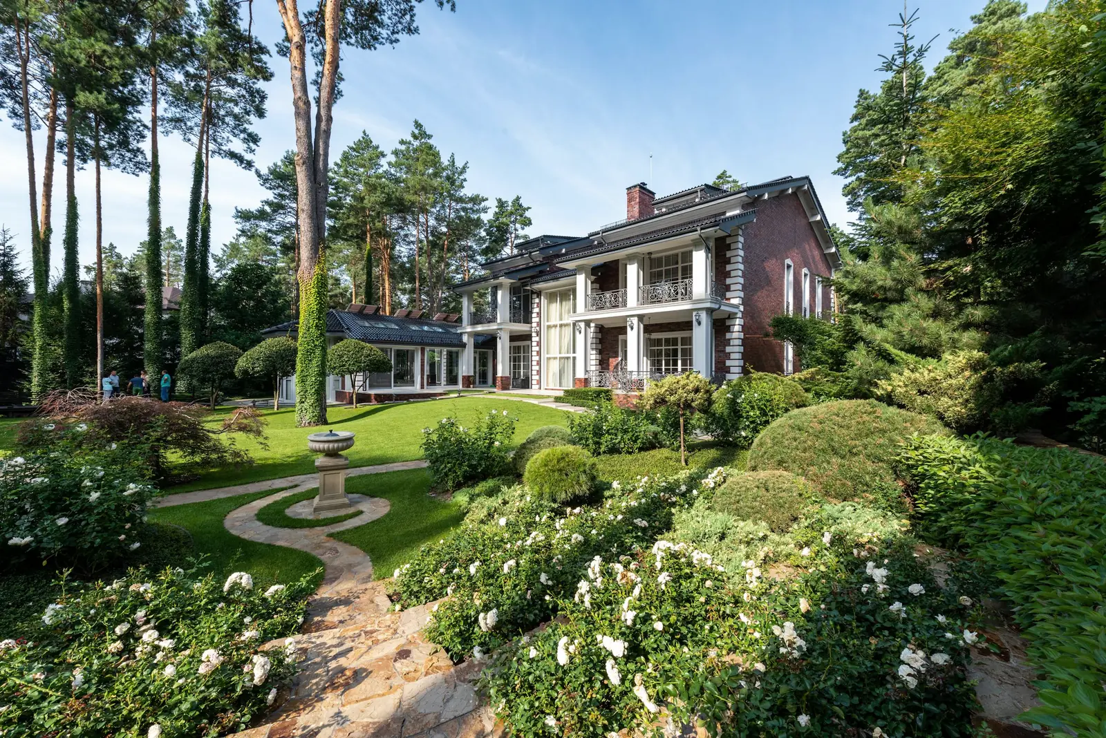 Freshly maintained lawn and planted beds in front of a large home
